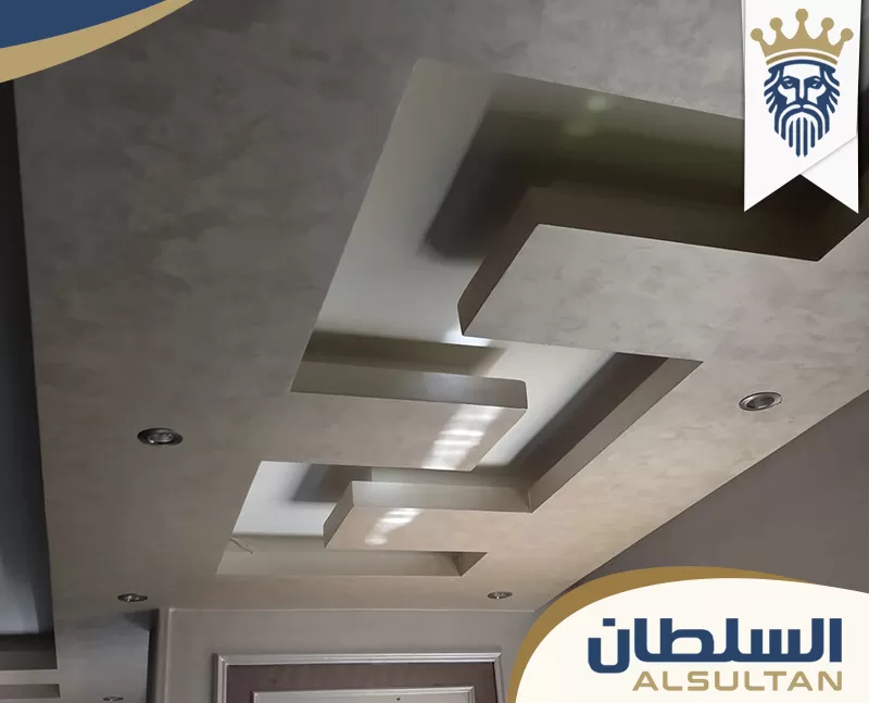 سقف جبس بورد هندسي متعدد المستويات مع إضاءة مخفية وسبوتات مدمجة بتشطيب داخلي حديث في دبي سقف جبس بورد هندسي متعدد المستويات مع إضاءة مخفية وسبوتات مدمجة بتشطيب داخلي حديث في دبي