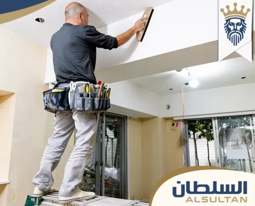 فني محترف يقوم بصنفرة وتسوية زوايا الجبس بورد لضمان استواء السطح قبل الدهان.